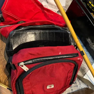 Sale Photo Thumbnail #239: Assorted travel bags and toiletry kits, including a red Wenger SwissGear shoulder bag and a vintage black leather Utili-Kit case.