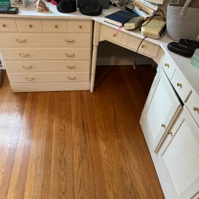 Sale Photo Thumbnail #230: White painted wood corner desk unit featuring a chest of drawers, a central writing surface, and a cabinet with louvered doors.