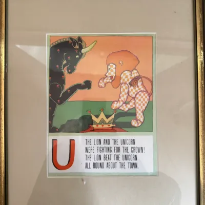 Sale Photo Thumbnail #198: Framed vintage nursery rhyme print featuring "The Lion and the Unicorn" illustration for the letter U, housed in a gold-toned wooden frame with a beige mat.