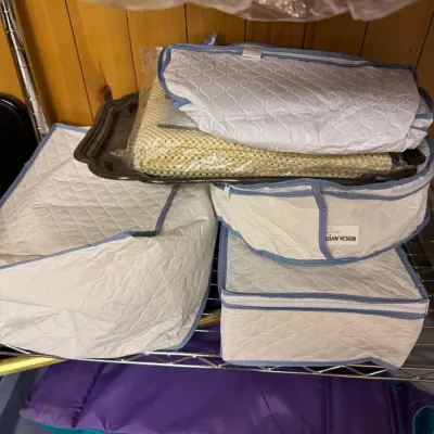 Sale Photo Thumbnail #89: Lillian Vernon quilted china storage cases in white with blue trim, shown stacked on a wire shelf.