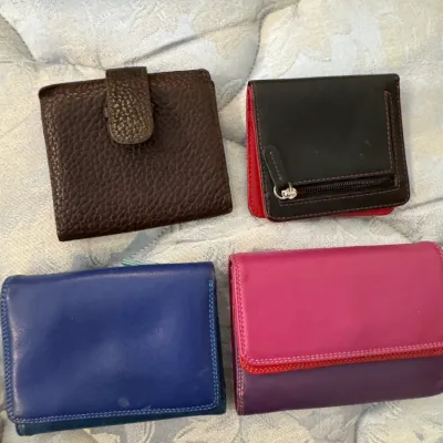 Sale Photo Thumbnail #47: Collection of four small leather wallets in various colors, including textured brown, black with red trim, solid blue, and a pink and purple color-blocked design.