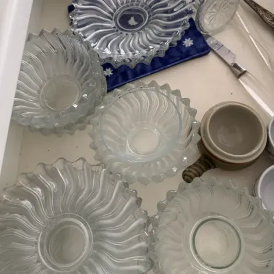 Sale Photo Thumbnail #331: Collection of vintage clear glass bowls and plates featuring a distinctive ribbed, swirling sunburst pattern.