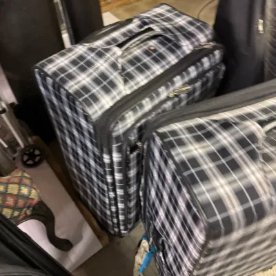 Sale Photo Thumbnail #78: Two matching black and white plaid soft-sided rolling suitcases, showing light wear.