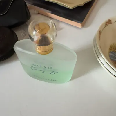 Sale Photo Thumbnail #229: Vintage bottle of Giorgio Armani Acqua Di Gio eau de toilette, partially used, with its original gold-accented cap.