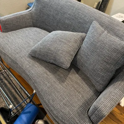 Sale Photo Thumbnail #266: Contemporary gray textured fabric loveseat with two matching throw pillows, featuring a curved back and clean lines.