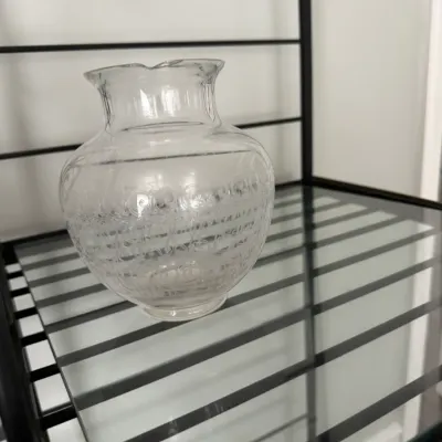 Sale Photo Thumbnail #352: Vintage clear glass vase featuring an etched scrollwork band around its bulbous body, displayed on a glass-shelved metal rack.