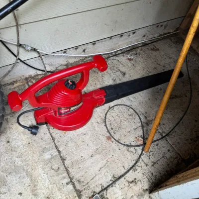 Sale Photo Thumbnail #72: Toro Ultra Blower Vac electric leaf blower with a red plastic body and black nozzle attachment, showing some signs of outdoor use.