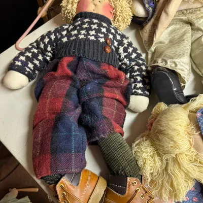 Sale Photo Thumbnail #128: Vintage handmade soft-sculpture doll featuring curly yarn hair, a houndstooth sweater, plaid trousers, and miniature brown work boots.