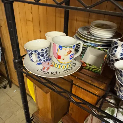 Sale Photo Thumbnail #156: Vintage Arabia of Finland ceramic tableware, including a "Munch Munch" child's plate and mug set alongside blue and white floral patterned cups.