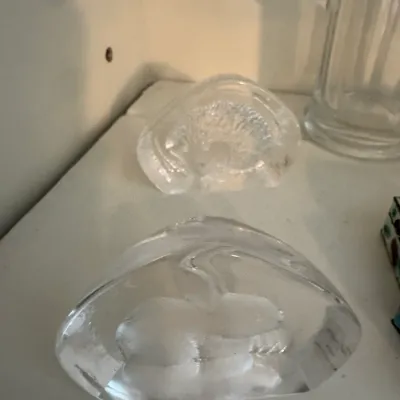 Sale Photo Thumbnail #189: Two vintage clear art glass paperweights, one featuring a textured hedgehog design and the other a smooth rabbit motif.
