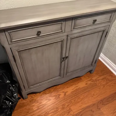 Sale Photo Thumbnail #211: Contemporary wooden sideboard with a distressed gray wash finish, featuring two drawers and a double-door cabinet with dark metal hardware.