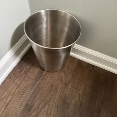 Sale Photo Thumbnail #292: Brushed stainless steel wastebasket with a tapered design, showing minor surface wear.
