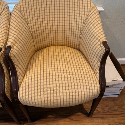 Sale Photo Thumbnail #61: Traditional barrel-back armchair featuring yellow and brown plaid upholstery with dark wood trim and legs.