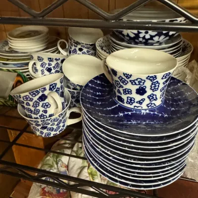 Sale Photo Thumbnail #39: Vintage blue and white floral ceramic teacups and saucers, stacked on a wire shelf.