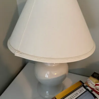 Sale Photo Thumbnail #228: White ceramic table lamp with a rounded base and a matching white fabric empire shade.