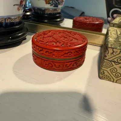 Sale Photo Thumbnail #58: Chinese cinnabar lacquer round trinket box featuring intricate carved floral and scroll motifs.
