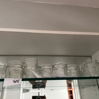 Sale Photo Thumbnail #332: Collection of clear glass mason jars in various sizes, displayed on a glass shelf.