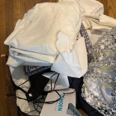 Sale Photo Thumbnail #276: Assorted household items including folded white linens, a Moen Belfield pivoting paper holder in its box, and a crystal-accented light fixture.