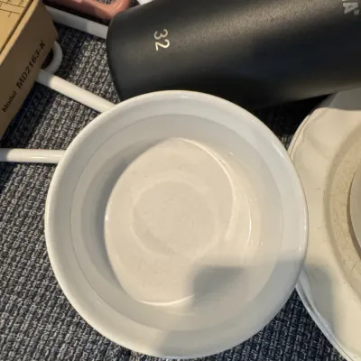 Sale Photo Thumbnail #300: White ceramic ramekin or small baking dish, shown alongside a black Takeya insulated water bottle and other household items.