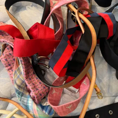 Sale Photo Thumbnail #172: Assorted collection of fashion belts in various materials, including leather, woven fabric, and patterned canvas.