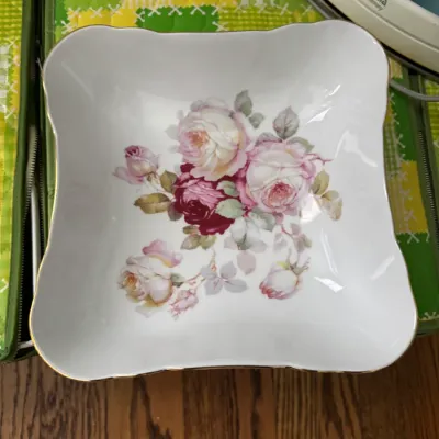 Sale Photo Thumbnail #322: Vintage square porcelain serving bowl featuring a scalloped gold-trimmed rim and a central pink and red rose floral motif.