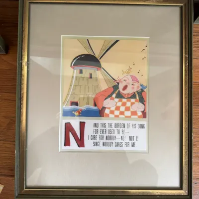 Sale Photo Thumbnail #202: Framed vintage nursery rhyme print featuring the letter 'N' and an illustration of a miller singing by a windmill, housed in a gold-accented green frame.