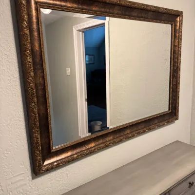 Sale Photo Thumbnail #212: Large rectangular wall mirror featuring a wide, ornate frame with a mottled bronze and gold finish.