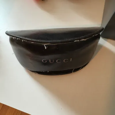 Sale Photo Thumbnail #223: Vintage black Gucci clamshell eyewear case showing significant wear and fraying along the edges.