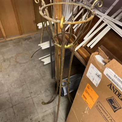 Sale Photo Thumbnail #79: Vintage brass-plated metal plant stand with scroll details and a tripod base, showing some surface wear and tarnish.