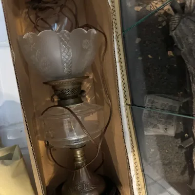 Sale Photo Thumbnail #254: Vintage electric hurricane lamp with a clear glass fount, frosted glass shade with ruffled edge, and a brass-finished base, stored in a cardboard box.