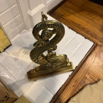 Sale Photo Thumbnail #57: Vintage brass fireplace tool stand featuring an ornate, stylized dragon or serpent design with textured scales.