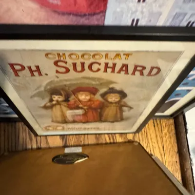 Sale Photo Thumbnail #253: Framed vintage-style advertisement print for Chocolat Ph. Suchard, featuring three children under an umbrella.