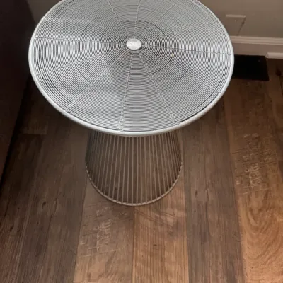 Sale Photo Thumbnail #317: Mid-century modern style wire side table with a circular top and a tapered pedestal base, finished in a light gray or silver color.