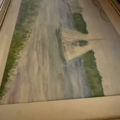 Sale Photo Thumbnail #83: Framed watercolor painting depicting a sailboat on a river, housed in a gold-finished frame with a wide mat.