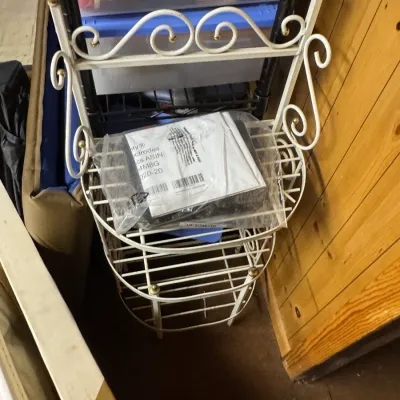 Sale Photo Thumbnail #111: Vintage white-painted wrought iron baker's rack or plant stand featuring scrollwork details and brass-toned finials.