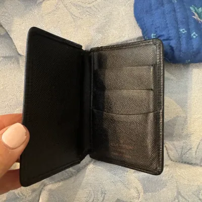 Sale Photo Thumbnail #169: Louis Vuitton black Taiga leather card holder, showing the interior card slots and embossed brand logo.