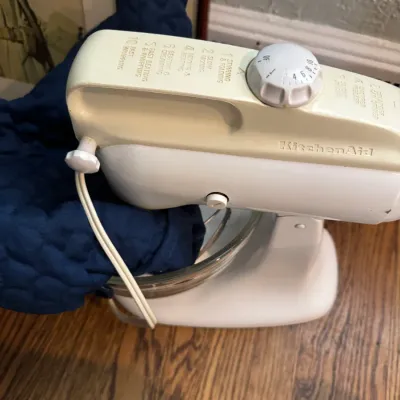 Sale Photo Thumbnail #243: Vintage KitchenAid stand mixer in cream and white, featuring a glass mixing bowl and speed control dial.