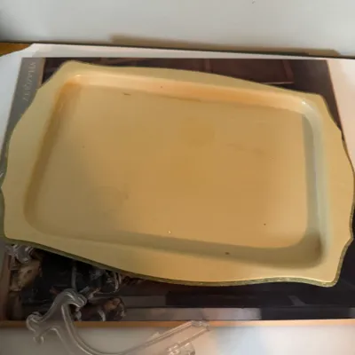 Sale Photo Thumbnail #217: Vintage mid-century fiberglass serving tray in a pale yellow hue, featuring a textured surface and scalloped edges with gold-toned trim.