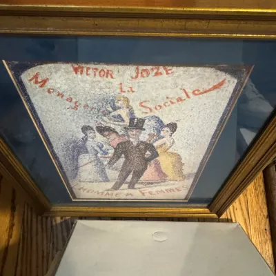 Sale Photo Thumbnail #252: Framed pointillist-style print of Georges Seurat's 'L'Homme à Femmes' book cover illustration for Victor Joze's 'La Ménagerie Sociale', presented in a gold-finished frame with a blue mat.