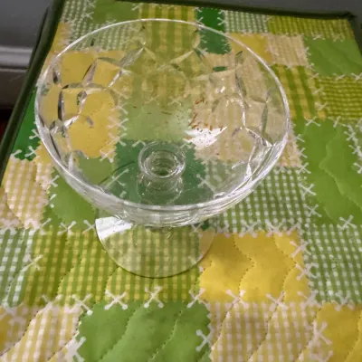 Sale Photo Thumbnail #324: Vintage cut glass compote bowl with a diamond pattern, resting on a green and yellow quilted surface.