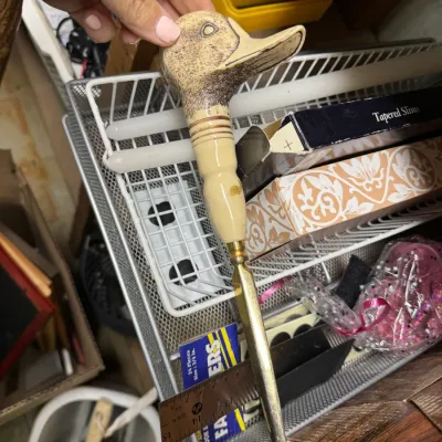 Sale Photo Thumbnail #102: Vintage letter opener featuring a carved faux-scrimshaw duck head handle and a brass blade.