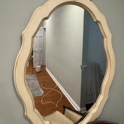 Sale Photo Thumbnail #34: Vintage French Provincial style oval wall mirror featuring an off-white painted frame with a carved gold-tone crest.
