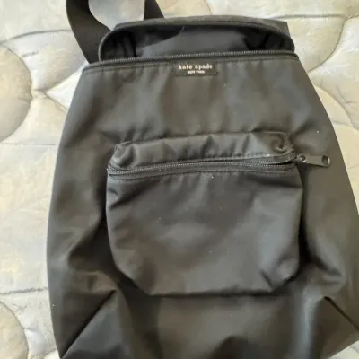 Sale Photo Thumbnail #32: Kate Spade New York black nylon backpack featuring a zippered front pocket and top handle, showing light wear.