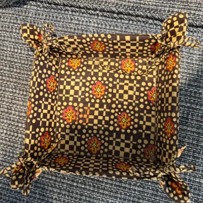Sale Photo Thumbnail #304: Vera Bradley fabric vanity tray or catchall basket featuring a brown, yellow, and red geometric floral pattern with tie corners.