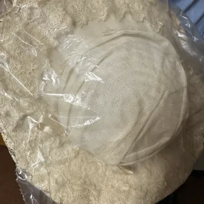 Sale Photo Thumbnail #154: Vintage wide-brimmed white lace sun hat, preserved in a protective plastic sleeve.