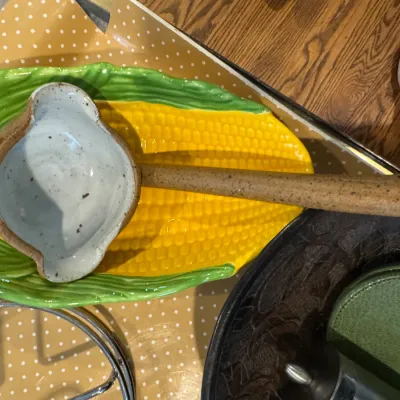 Sale Photo Thumbnail #260: Vintage ceramic corn-on-the-cob serving platter paired with a rustic, speckled stoneware ladle.