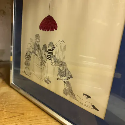 Sale Photo Thumbnail #15: Framed whimsical ink drawing by Julie Conover, depicting a grandmother reading to children under a red lamp, presented in a blue mat and silver-toned metal frame.