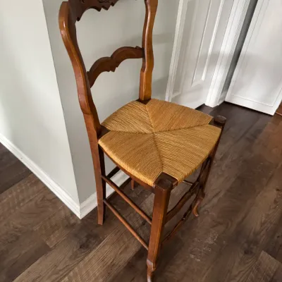Sale Photo Thumbnail #66: French country style wooden barstool featuring a carved ladderback design and a woven rush seat.
