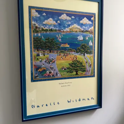 Sale Photo Thumbnail #291: Framed exhibition poster featuring "Sydney Harbour, Australia 1992" by artist Narelle Wildman, presented in a blue frame.
