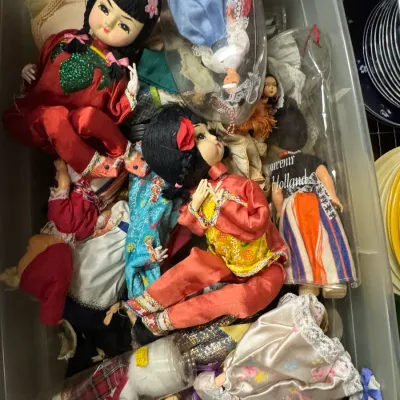 Sale Photo Thumbnail #116: Collection of vintage international souvenir dolls, including Asian and European regional costumes, stored in a plastic bin.